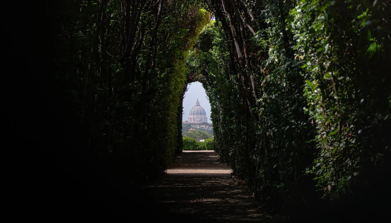 View through the Aventine keyhole along a garden avenue toward St. Peter's dome